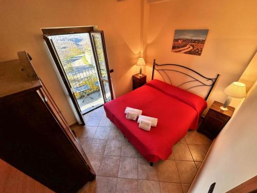 a bedroom with a red bed with two towels on it at Agriturismo Cantine Bevione - Rooms with air conditioning in Belvedere Langhe