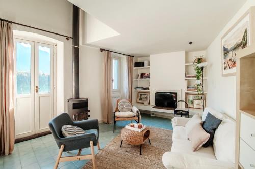 ein Wohnzimmer mit einem weißen Sofa und Stühlen in der Unterkunft Olea - by MyHomeInComo in Ossuccio
