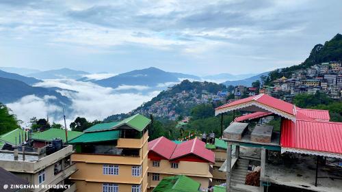 a group of buildings with mountains in the background at Hotel Zingkham Residency in Gangtok