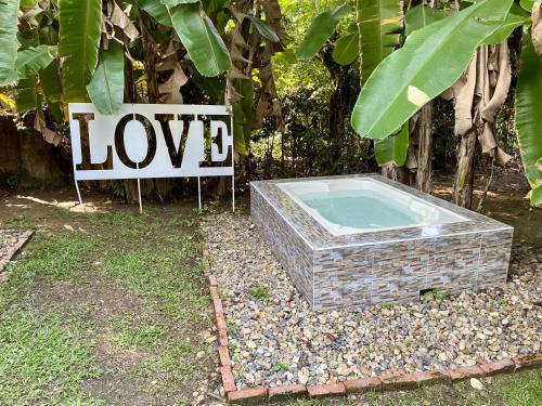 Ein Schild, auf dem Liebe neben einer Badewanne steht. in der Unterkunft Hostel Glamping Mistiko Safari - Carmen de apicala in Carmen de Apicalá