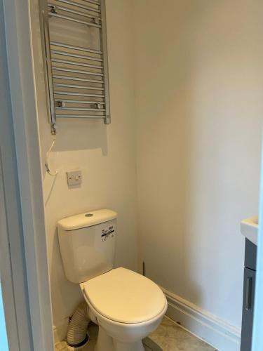 a bathroom with a white toilet and a window at Cosy Studio in Manchester