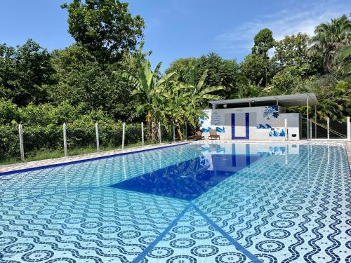 a large swimming pool with a blue at Hostel Glamping Mistiko Safari - Carmen de apicala in Carmen de Apicalá