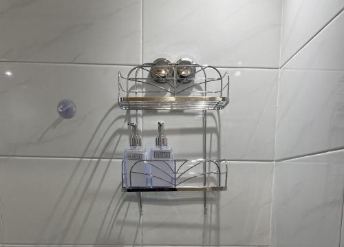 a shelf on the wall of a shower in a bathroom at Walk to Lcy Airport Excel Dlr 1Br Flat in London