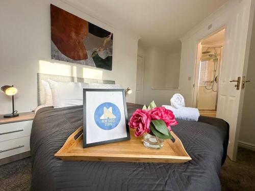 a tray with a picture and flowers on a bed at No. 19 by Blue Skies Stays in Stockton-on-Tees