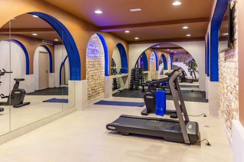 a gym with treadmills and ellipticals and blue arches at Riad Nyla Wellness and Spa in Marrakesh