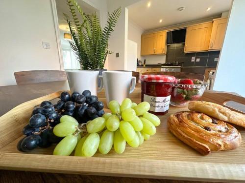 a cutting board with grapes and bagels on a table at No. 19 by Blue Skies Stays in Stockton-on-Tees