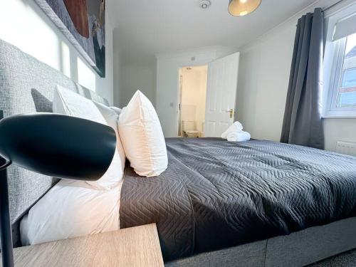 a bedroom with a bed with a black blanket and white pillows at No. 19 by Blue Skies Stays in Stockton-on-Tees