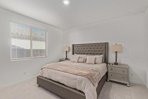 a white bedroom with a large bed and a window at AT YOUR SERVICE - Modern Amenities, Urban Location, Sophisticated Style in Phoenix
