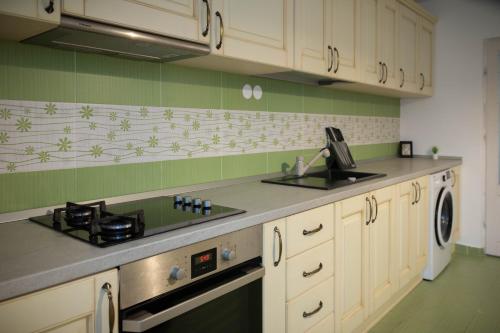 a kitchen with white cabinets and a stove top oven at TheRefuge in Curtea de Argeş