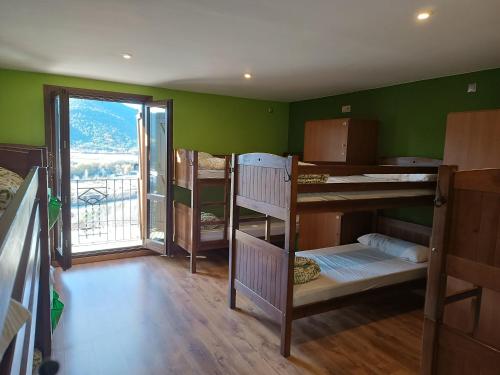 Pokój z kilkoma łóżkami piętrowymi i balkonem w obiekcie Mora de Nuei w mieście Aínsa