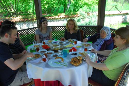 Un groupe de personnes assises autour d'une table et mangeant de la nourriture dans l'établissement Mehves Hanim Konagi, à Safranbolu