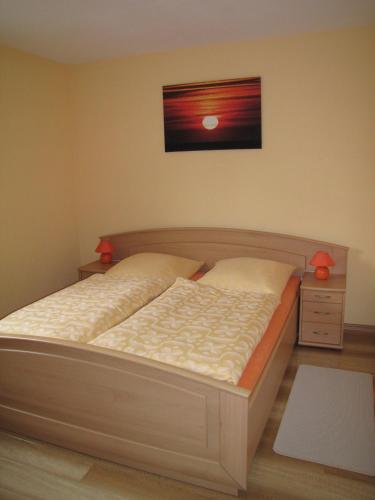 a bedroom with a bed and a picture on the wall at Stollenklause in Hormersdorf