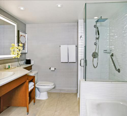 a bathroom with a shower and a toilet and a sink at Pan Pacific Toronto in Toronto