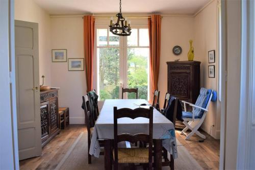une salle à manger avec une table et des chaises et une fenêtre dans l'établissement Belle villa en granit rose VUE SUR MER à PERROS-GUIREC - Réf 943, à Perros-Guirec