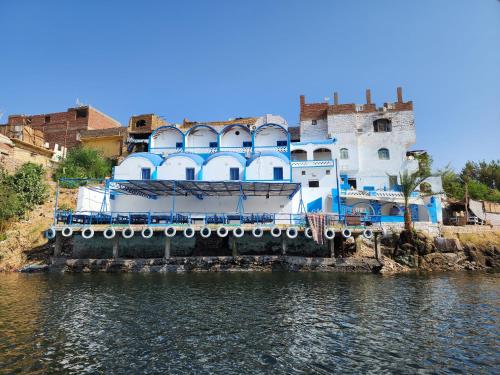 a blue and white building next to a body of water at Endo Mando in Shellal