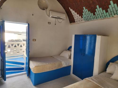 mały pokój z 2 łóżkami i oknem w obiekcie Endo Mando w mieście Shellal