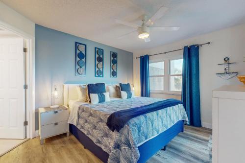 a blue bedroom with a bed and a window at Gulf Strand Resort 308 in St Pete Beach