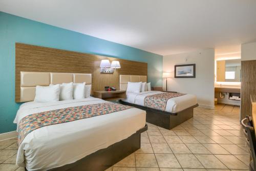 a hotel room with two beds and a bathroom at Beachside Resort Hotel in Gulf Shores
