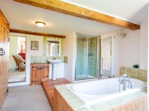 a bathroom with a tub and a shower and a sink at 4 Bed in Gillingham 80670 in West Stour