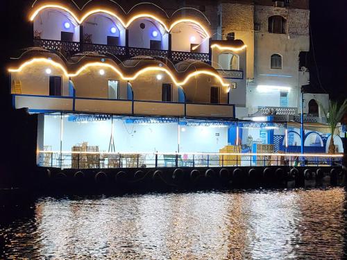 a building with lights on the water at night at Endo Mando in Shellal