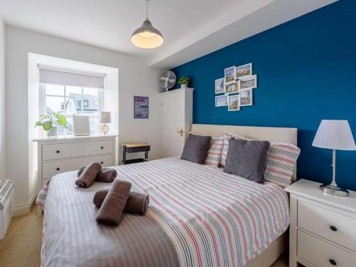 a bedroom with a bed with a blue wall at 1 Bed in Tenby FB056 in Tenby