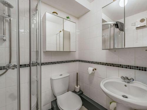 a white bathroom with a toilet and a sink at 1 Bed in Tenby FB056 in Tenby