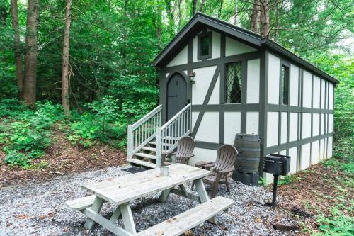 a black and white shed with a picnic table and a bench at Tiny Home Cottage Near the Smokies #3 Ingrid in Sevierville