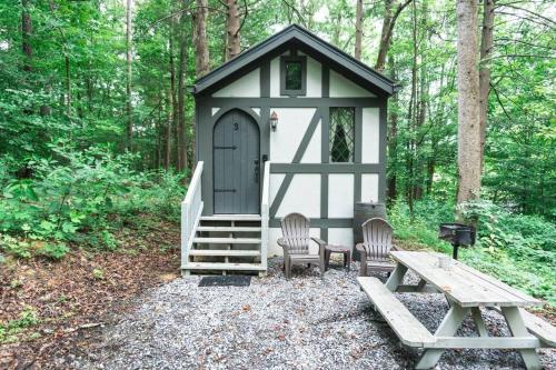 a small cabin with two chairs and a picnic table at Tiny Home Cottage Near the Smokies #3 Ingrid in Sevierville