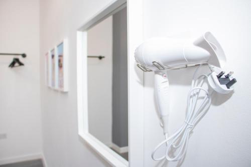 a hairdryer on a wall next to a mirror at Chill Nexus Oasis in Liverpool