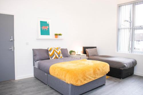 a bedroom with a bed and a couch and a window at Chill Nexus Oasis in Liverpool