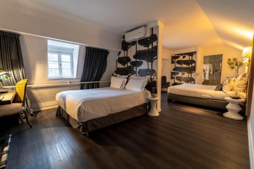 a hotel room with two beds and a desk and a desk at Hotel Rohan, Centre Cathédrale in Strasbourg