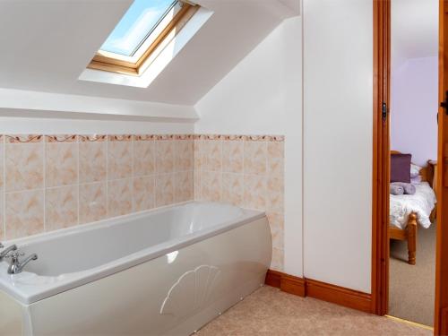 a bath tub in a bathroom with a skylight at 5 Bed in Hay on Wye BN358 in Llyswen