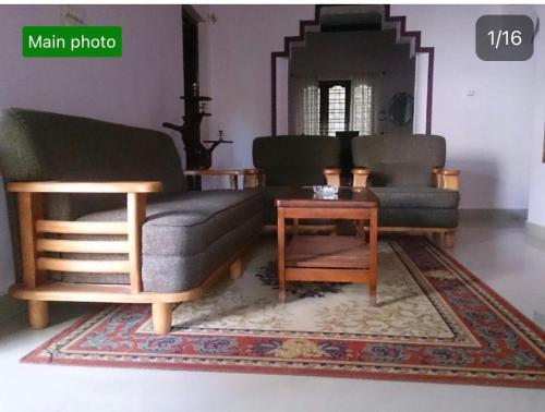 a living room with two couches and a coffee table at Dhruva Homestay in Madikeri