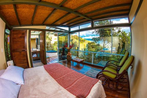 ein Schlafzimmer mit einem Bett und einem großen Fenster in der Unterkunft ANCESTRAL GLAMPING in Barbosa