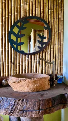 a bathroom sink with a mirror on a wooden wall at ANCESTRAL GLAMPING in Barbosa