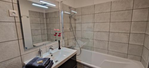 La salle de bains est pourvue d'un lavabo, d'une douche et d'une baignoire. dans l'établissement Bleautiful "Aliénor" Charmant appartement avec terrasse, à Fontainebleau
