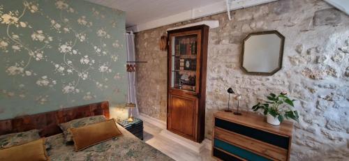 een woonkamer met een bank en een spiegel bij Bleautiful "Aliénor" Charmant appartement avec terrasse in Fontainebleau