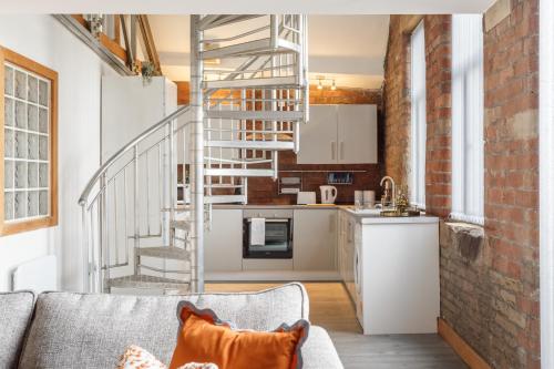 a living room with a couch and a spiral staircase at Broadgate Penthouse Apartment in Bradford