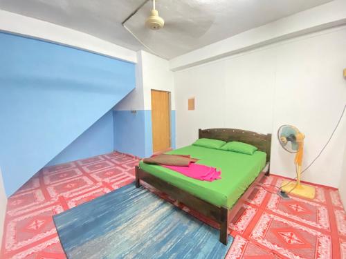 ein Schlafzimmer mit einem grünen Bett in einem Zimmer in der Unterkunft MY GUNUNG HOTEL BUDGET 