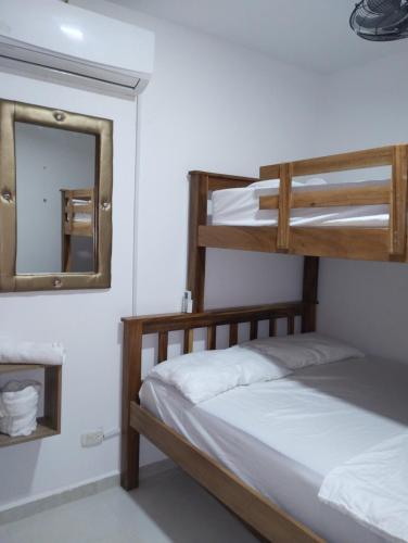 1 dormitorio con 2 literas y espejo en Mirador Piso 17 - Acogedor y Exclusivo apartamento en piso 17 con vista al mar, en Cartagena de Indias
