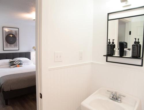 a bathroom with a sink and a mirror and a bed at The Nightingale Motel in Pagosa Springs