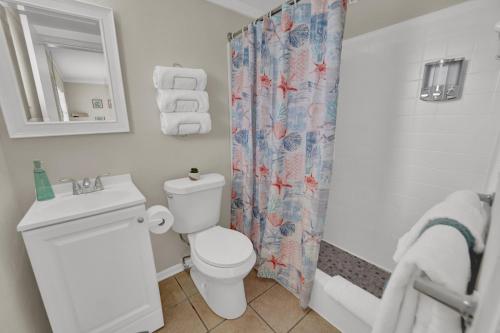 a bathroom with a toilet and a shower curtain at Sea Foam Suites in Panama City Beach