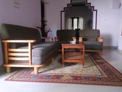 a living room with two couches and a coffee table at Dhruva Homestay in Madikeri