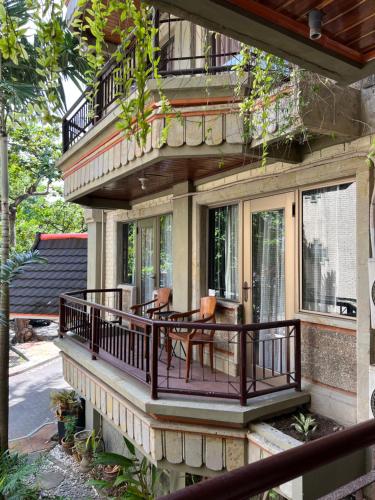 una casa con balcone arredato con tavolo e sedie di Galayanee’s Resort Apartment a Seminyak