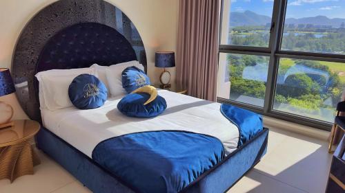 a bedroom with a large bed with blue pillows at Mullet Bay Suites - Your Luxury Stay Awaits in Cupecoy