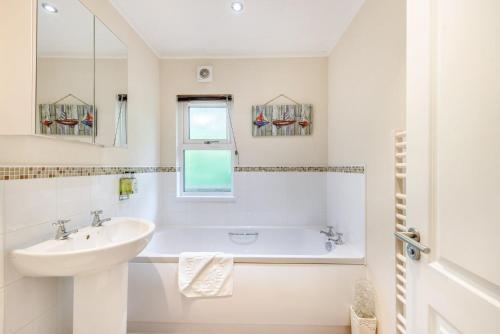 a white bathroom with a sink and a bath tub at HB Hornbeam Lodge 04 in Narberth