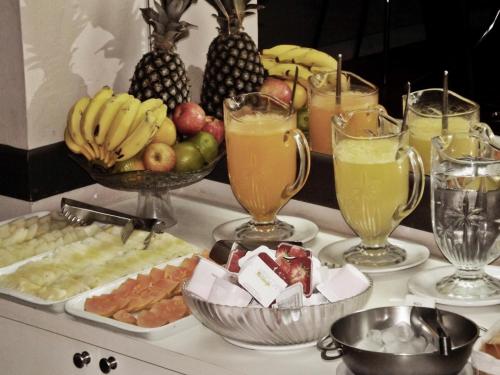 a buffet of fruit and drinks on a table at Pousada do Pescador in Penha
