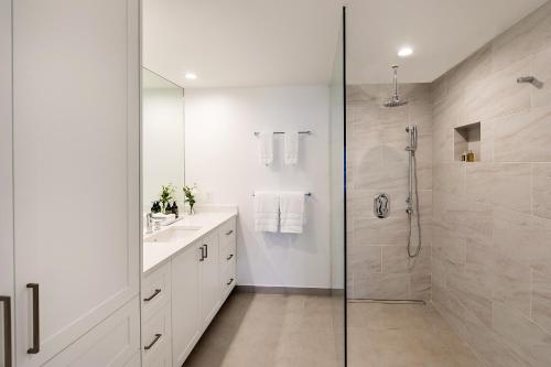 a white bathroom with a shower and a sink at Carpe Diem 3 BR Condo in The Bight Settlements