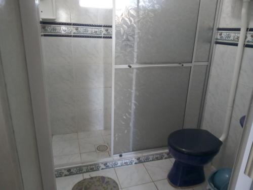 uma casa de banho com um chuveiro e um WC azul em Apartamento para casal. Perto do mar em Tramandaí