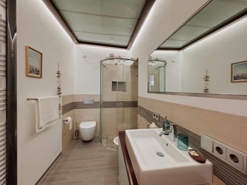 a bathroom with a sink and a toilet and a mirror at Lake House in Nago-Torbole